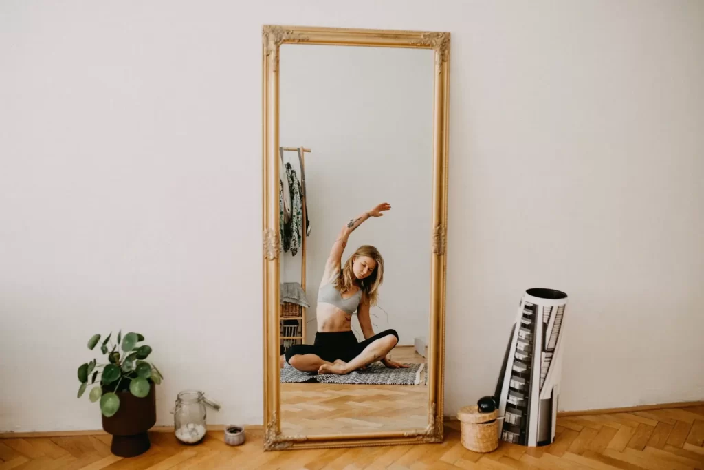 Young woman sitting on the floor in a yoga stretch – click to explore CBD support for an active lifestyle.