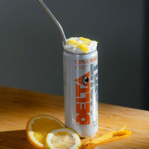 can of delta water mango with straw, gray back ground and orange and mango slices