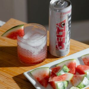delta water can on table with watermelon slices around it
